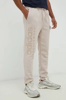 Zdjęcie produktu adidas spodnie dresowe męskie kolor beżowy z aplikacją