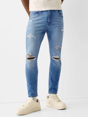 Zdjęcie produktu Bershka Jeansy Skinny Z Przetarciami I Plamami Farby Mężczyzna Wyblakły Niebieski