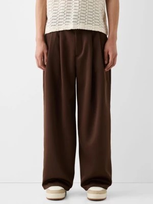 Zdjęcie produktu Bershka Eleganckie Satynowe Spodnie Z Zakładkami Mężczyzna Brązowy