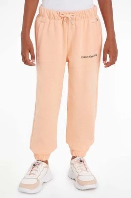 Zdjęcie produktu Calvin Klein Jeans spodnie dresowe dziecięce kolor pomarańczowy gładkie