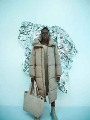 Zdjęcie produktu Długa pikowana damska kurtka z wysokim kołnierzem- beżowa Moodo