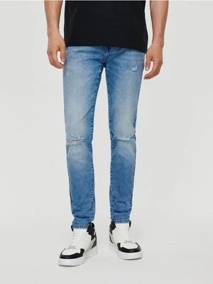 Zdjęcie produktu Jansnoniebieskie jeansy slim fit z przetarciami House